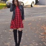 Vestido xadrez vermelho com botas acima do joelho e jaqueta de couro