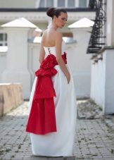 Un vestido de novia hinchado con un lazo rojo y cordones.