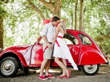 Vestuvinė suknelė su raudonu diržu ir raudonu automobiliu