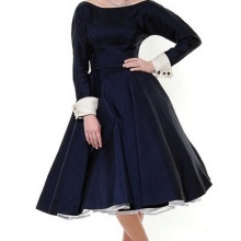 En puffig blå klänning med långa ärmar och vita manschetter på dem i stil på 50-talet