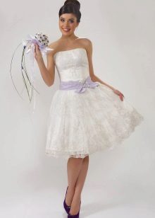 La novia en un vestido de novia de encaje con un ramo brillante