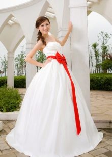 Un magnífico vestido de novia con un lazo escarlata.