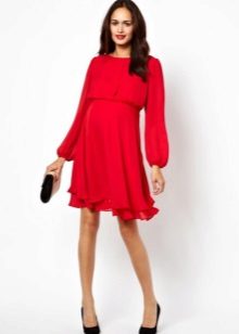 Punainen mekko, jossa pitkät hihat ja löysä hame raskaana oleville naisille