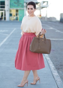 Roze pluizige rok onder de knie in combinatie met een perzikkleurige blouse