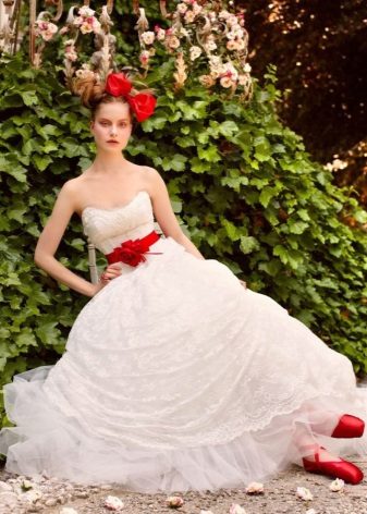 Vestido de novia con lazo y accesorios rojos.
