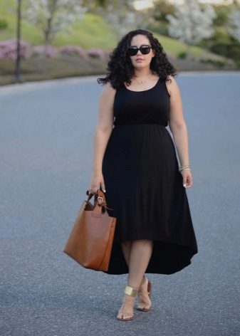 Musta mekko, jossa on epäsymmetrinen hame täydellisille, yhdessä kultaisten sandaalien ja ruskean laukun kanssa