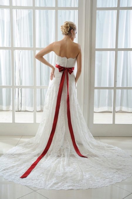 Vestuvinė suknelė su raudonu lanku nugaroje