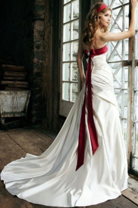 Vestuvinė suknelė su raudonu kaspinu ant liemenės