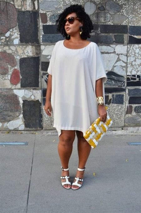 Biele tunické šaty pre ženy s nadváhou v kombinácii s bielymi sandálmi a zlatými doplnkami