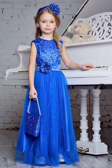 Vestido elegante em um piso azul para a menina
